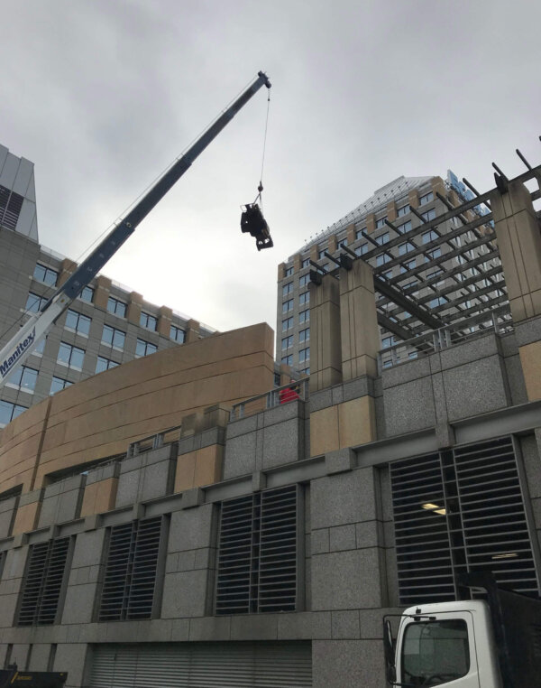 large crane suspended over commercial building