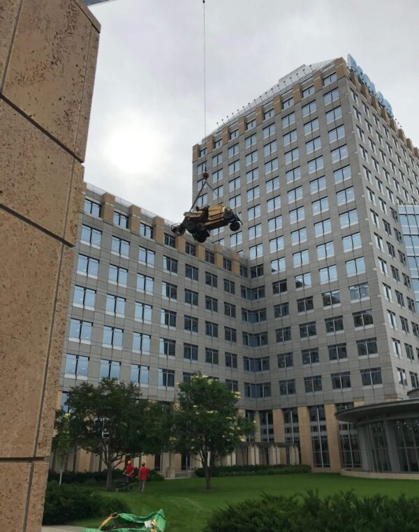 crane lowering equipment into courtyard of commercial building